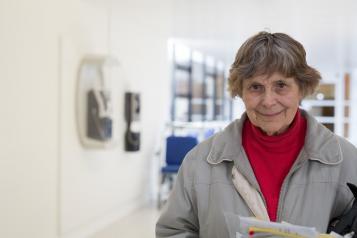 Elderly lady standing in a hospital corridor