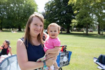 Woman in a sunny park with a young baby